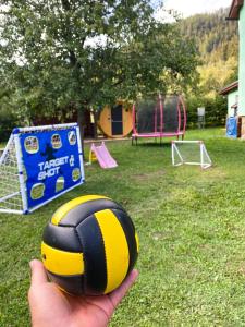 a person holding a volleyball in front of a playground at VILLA LÚČKY in Lúčky