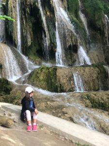 路奇基的住宿－VILLA LÚČKY，坐在瀑布前的女孩