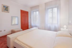 奧帕蒂亞的住宿－Holiday Home "Opatija"，白色卧室设有一张白色大床和两个窗户