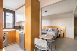 pokój z łóżkiem, stołem i kuchnią w obiekcie APARTAMENTOS LAS OLAS BY PANTIN w mieście Valdoviño
