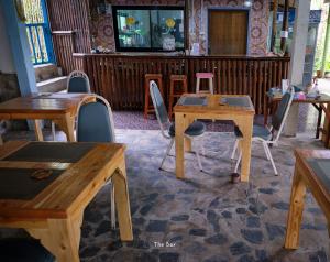 a room with two wooden tables and chairs at Hill Station Hostel at Chor Chaba in Ko Kood