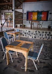 a table and chairs in a room with stained glass at Hill Station Hostel at Chor Chaba in Ko Kood