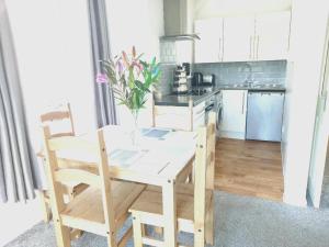 a kitchen with a wooden table and chairs in a room at Angel Lane Alnwick Apartment in Alnwick +3 photos