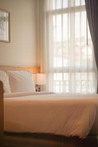 a bedroom with a bed with a window at Ago Hotel Chinatown in Bangkok