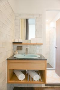 a bathroom with a sink and a mirror at Ago Hotel Chinatown in Bangkok