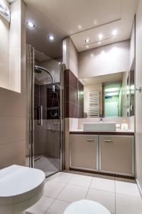 a bathroom with a shower and a sink and a toilet at Apartamenty Zielone Tarasy - visitopl in Kołobrzeg