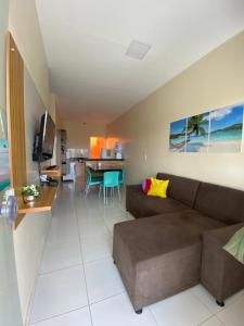 a living room with a brown couch and a table at Pousada Vila das Lagoas in Santo Amaro