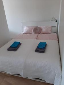 a white bed with two blue towels on it at New&Easy apartment in the center in Turku