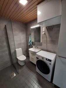 a small bathroom with a sink and a washing machine at New&Easy apartment in the center in Turku