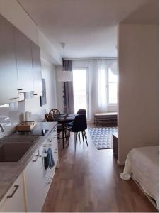 a kitchen with a sink and a table in a room at New&Easy apartment in the center in Turku