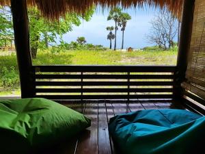 een slaapkamer met uitzicht op de oceaan vanuit een raam bij Wajonata Sumba in Baing