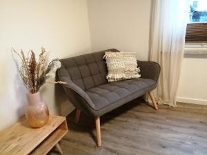 a gray couch in a living room with a table at Ferienhäuser Rosalinn und Felinchen in Eutin