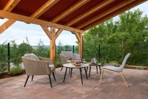 eine Terrasse mit Stühlen und einem Tisch auf einer Backsteinterrasse in der Unterkunft Studio LOVOR in the Green Countryside of Central Istria in Tinjan
