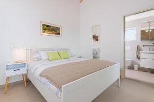 TinjanにあるStudio LOVOR in the Green Countryside of Central Istriaの白いベッドルーム(ベッド1台、バスルーム付)
