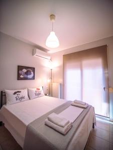 um quarto com uma cama grande e toalhas em Small Nest - Central Spot Apartments em Volos