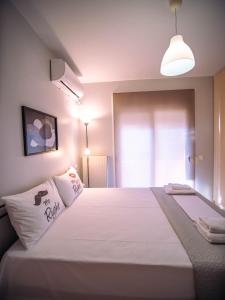 a bedroom with a large white bed with a light at Small Nest - Central Spot Apartments in Volos