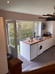 a kitchen with a sink and a washing machine at The Loft at Pen Orchard in Winscombe