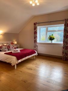 een slaapkamer met een bed en een raam bij The Loft at Pen Orchard in Winscombe