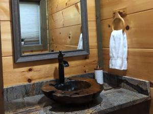 ein Bad mit einem Waschbecken und einem Spiegel in der Unterkunft The Overlook - '21 Cabin - Gorgeous Unobstructed Views - Fire Pit Table - GameRm - HotTub - Xbox - Lots of Bears in Gatlinburg