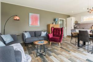 a living room with a couch and chairs and a table at 5 Sterne-Ferienhaus Eisvogel am See mit Sauna und Kamin in Krakow am See