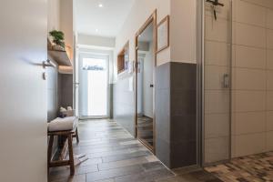 a bathroom with a walk in shower and a mirror at 5 Sterne-Ferienhaus Eisvogel am See mit Sauna und Kamin in Krakow am See