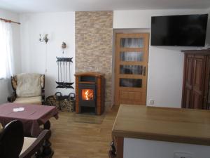 a living room with a fireplace and a room with a table at Chalupa Maršovice in Nové Město na Moravě