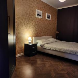 een slaapkamer met een bed en een tafel met een lamp bij Charme apartment in Jelgava