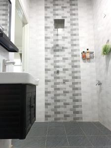 a bathroom with a shower with a sink and a shower at Aila Homestay Pendang in Pendang