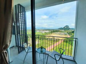 a balcony with two chairs and a view of a field at Onsen Suite at Sunway Lost World Tambun in Ipoh