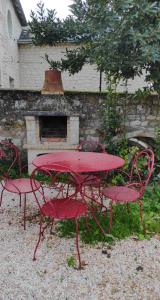- une table de pique-nique rouge, 2 chaises et une cheminée dans l'établissement Le Cottage et la Tiny des Cartes - 2 maisons, à LʼÎle Bouchard