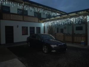 un coche aparcado frente a una casa con luces de Navidad en Casa de lângă pădure, en Sighetu Marmaţiei