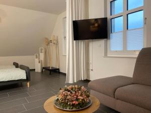 a living room with a couch and a table with flowers on it at Gemütliche Wohnung in Ahaus