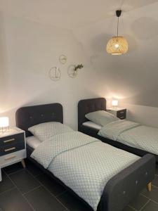 a room with two beds and a table and a lamp at Gemütliche Wohnung in Ahaus