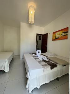 2 Betten in einem Zimmer mit einem Handtuch darüber in der Unterkunft Vila Kitemania in Prea