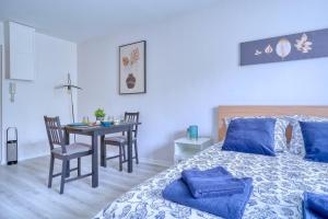 1 dormitorio con 1 cama y 1 mesa con sillas en Logement Elora en Evry-Courcouronnes
