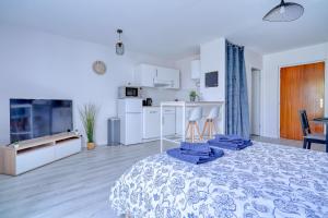 Habitación blanca grande con cama y cocina en Logement Elora en Evry-Courcouronnes