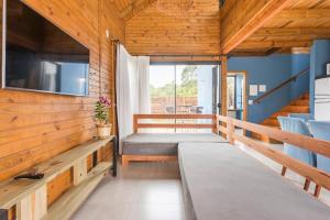 Habitación pequeña con cama y balcón. en Casa com Banheira, Piscina e Quadra de Areia en Imbituba