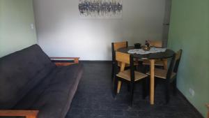 um quarto com uma mesa e cadeiras e um sofá em CABAÑAS VILLA CLUB 3 cerca del aeropuerto el palomar em Hurlingham