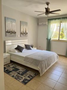 a bedroom with a large bed and a ceiling fan at Royal Seacrest new apartment B G2 ground floor in Paphos