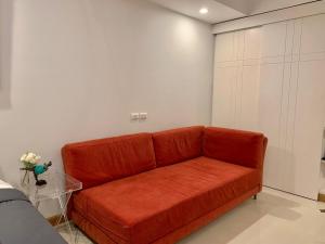 a orange couch in a living room at Supalai Oriental Place in Bangkok