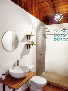 a bathroom with a sink and a toilet at ICO Living Hostel in Santa Teresa Beach