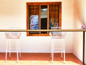 2 sillas y un bar en una habitación con ventana en ICO Living Hostel, en Santa Teresa Beach