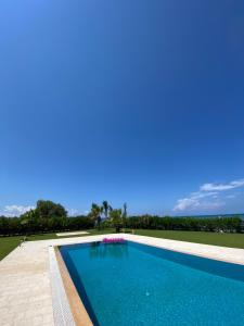 a blue swimming pool with a blue sky in the background at Greek Villas Justine View Beach in Kyllini