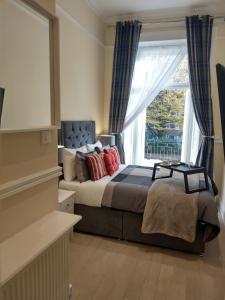 1 dormitorio con cama y ventana grande en Prime Inn, en Londres
