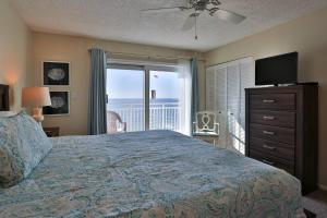 - une chambre avec un lit, une télévision et un balcon dans l'établissement 615 - Sunset Chateau, à St. Pete Beach