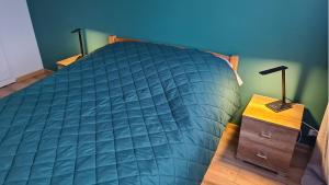 een slaapkamer met een blauw bed en een nachtkastje bij Spokojny Wypoczynek 4 in Ostrów Wielkopolski