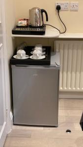 a stove in a kitchen with a tea kettle on top at Prime Inn in London