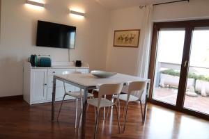 une salle à manger avec une table et des chaises blanches dans l'établissement Appartamento MarySol, à Alghero