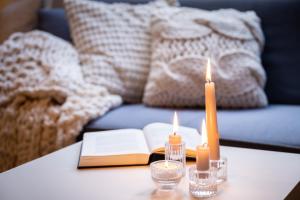 a table with two candles and an open book at APARTMENT KLAGENFURT - Apartment Wulfenia in Klagenfurt