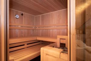 a wooden sauna with a clock on the wall at APARTMENT KLAGENFURT - Apartment Wulfenia in Klagenfurt